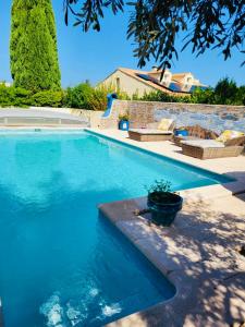 a swimming pool with blue water in a yard at Maison de Celya in Saint-Georges-dʼOrques