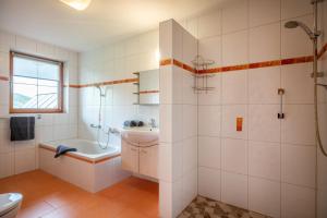 een badkamer met een bad, een wastafel en een toilet bij Ferienwohnung Schwabegghof in Ellmau