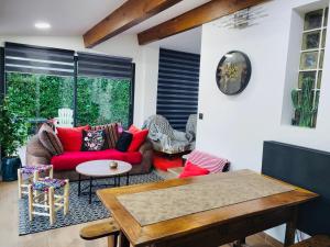 ein Wohnzimmer mit einem roten Sofa und einem Tisch in der Unterkunft Maison de Celya in Saint-Georges-dʼOrques