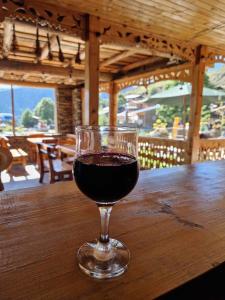 a glass of red wine sitting on a wooden table at Guesthouse Lasharai in Omalo