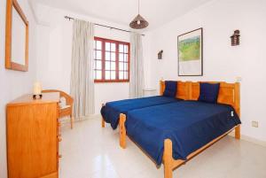 een slaapkamer met een bed met een blauw dekbed bij Villa Gemini in Guia