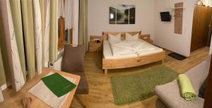een woonkamer met een bed en een bank bij Landhaus Engadin in Nauders