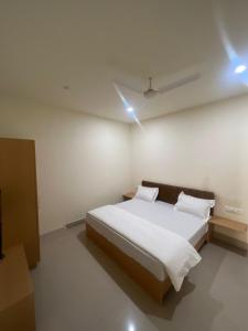 Schlafzimmer mit einem Bett mit weißer Bettwäsche und Kissen in der Unterkunft Ruhaneeyat Home Stay in Amritsar