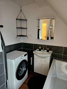 a bathroom with a washing machine and a sink at Vila Citadella in Svitavy