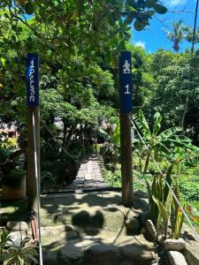 two blue signs in a garden with a walkway at Santuario Tayrona Hostel in Calabazo