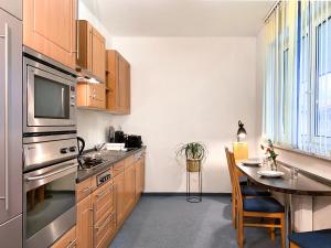 uma cozinha com armários de madeira e uma mesa de jantar em Mountain Apartment. The Art to live em Dietmannsried