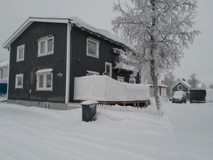 una casa cubierta de nieve delante en Kiruna accommadation Sandstensgatan 24, en Kiruna