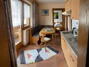 a small kitchen with a table and a living room at Landhaus Engadin in Nauders