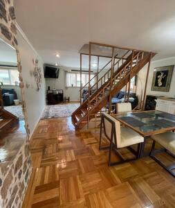 a living room with a staircase and a table at Nolibs Green Haven Sleeps 12 in Philadelphia