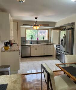 a large kitchen with stainless steel appliances and a table at Nolibs Green Haven Sleeps 12 in Philadelphia