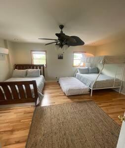 a living room with two beds and a ceiling fan at Nolibs Green Haven Sleeps 12 in Philadelphia