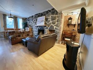sala de estar con sofá y chimenea de piedra en Hotel La Caravelle, en Baie-Comeau