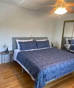a bedroom with a blue bed with a ceiling fan at Nolibs Green Haven Sleeps 12 in Philadelphia