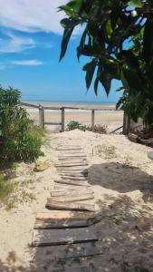 a path leading to a beach with a fence at Casa pé na areia in Hermenegildo +8 photos