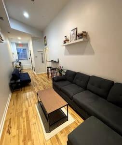 uma sala de estar com um sofá preto e uma mesa em Northern Liberties Fishtown Central Cozy Quaint em Filadélfia