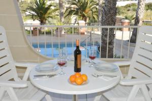 - une table avec une bouteille de vin et un bol de fruits dans l'établissement Villa Lyss Apartment 1, à Mellieħa
