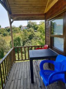 a table and chairs on the deck of a cabin at Ağva Bungalov Adult Only in Sile