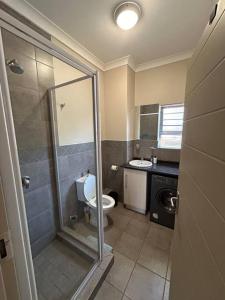 a bathroom with a shower and a toilet and a sink at Home away from Home in Pretoria