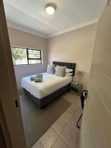 a bedroom with a bed with pillows and a window at Home away from Home in Pretoria