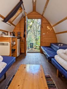a room with two beds and a table in a cabin at Rubha Phoil in Ardvasar