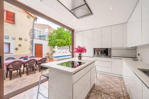 eine Küche mit weißen Schränken und einem großen Fenster in der Unterkunft Sa Llimonera de Binissalem, piscina privada ideal familias, 6 dormitorios con aire acondicionado in Binissalem