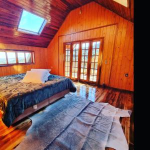 1 dormitorio con 1 cama en una habitación de madera en Pousada nevadas da Serra en Urupema