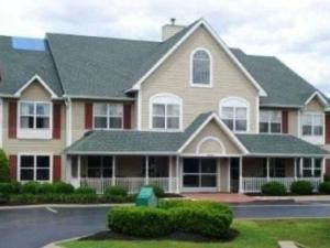 una casa grande con una señal verde delante de ella en Radiant Inn and Suites, en Murfreesboro