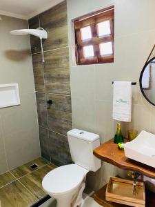 a bathroom with a toilet and a sink at Casa Santa Felicidade - Gravatá in Gravatá