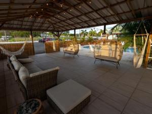 a patio with chairs and a hammock and a table at El Flamingo Beach Club in Manati