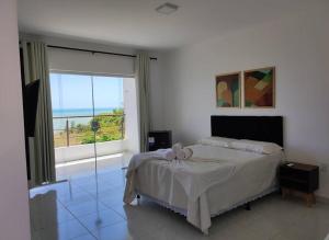 a bedroom with a bed and a large window at Encantu's pousada in Conde