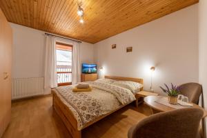 um quarto com uma cama, uma mesa e uma televisão em Penzión pod Kýčerou em Zuberec