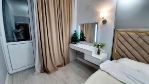 1 dormitorio con cama, lavabo y espejo en Шолпан сити 2\12, en Almaty