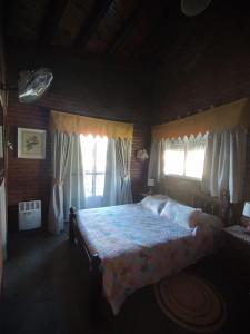 um quarto com uma cama e duas janelas em Gracias Viejo em Merlo