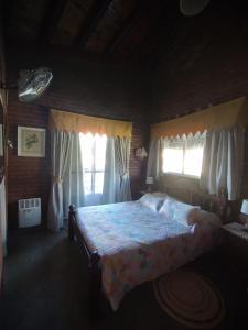 a bedroom with a bed and two windows at Gracias Viejo in Merlo +25 photos