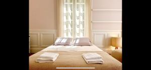 エトルタにあるSuite avec grande terrasse et parc - gîte classé 4 étoilesのタオルが敷かれたベッドのある寝室