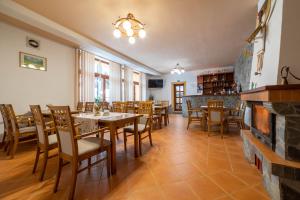 une salle à manger avec des tables, des chaises et une cheminée dans l'établissement Penzión pod Kýčerou, à Zuberec