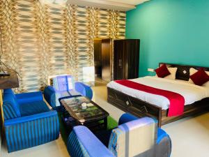 肯巴加爾的住宿－Hotel Treasure OF Kumbhalgarh，一间卧室配有一张床、蓝色的椅子和一张桌子