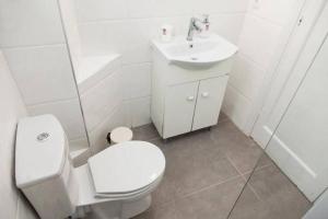 a white bathroom with a toilet and a sink at Ipeirou Central Athens in Athens