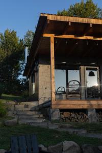 une maison dotée d'une terrasse avec deux chaises dans l'établissement Гірські будиночки, à Zhdenievo