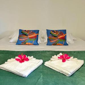 ein Bett mit zwei Handtüchern und zwei Kissen darauf in der Unterkunft Pousada Canto do sabiá Imbassaí in Imbassai