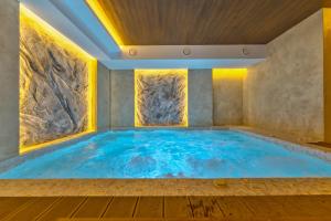una gran piscina en una habitación con una pared de piedra en Mons Vita Zlatibor, en Zlatibor
