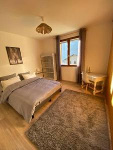 a bedroom with a bed and a desk and a window at Chalet de montagne in Séez