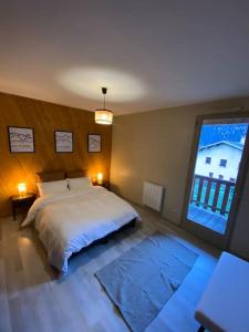 a bedroom with a bed and a large window at Chalet de montagne in Séez +14 photos