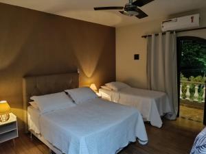 a bedroom with two beds and a window at Flat Miguel Pereira in Miguel Pereira