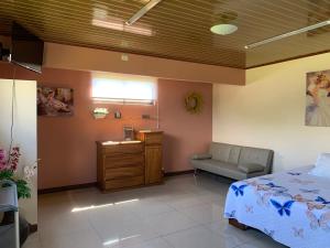1 dormitorio con cama, escritorio y silla en Disfruta del contacto con la naturaleza, en Puntarenas