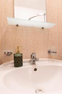 a bathroom sink with a soap dispenser on it at Light One Bed Flat next to the Ski Lift in Bansko