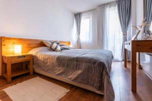 a bedroom with a bed with a wooden headboard at Light One Bed Flat next to the Ski Lift in Bansko
