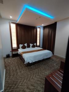 a hotel room with two beds and a blue light at ريستو للشقق المخدومة in Jeddah