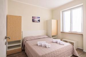um quarto com uma cama com duas toalhas brancas em Lake Maggiore Holiday Apartment em Feriolo