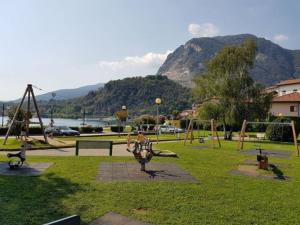 a park with a bunch of playground equipment in the grass at Lake Maggiore Holiday Apartment in Feriolo
